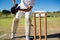 Low section of wicket keeper standing by stumps during match