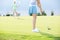 Low section of woman playing golf with female friend