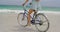 Low section of woman riding a bicycle on the beach 4k