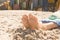 Low section of woman sitting on sand against beach huts