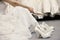 Low section of woman sitting with variety of footwear in bridal boutique