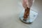 Low section of woman standing on bathroom scale