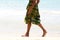 Low section woman walking barefoot along the seashore