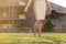 Low section of young businesswoman holding footwear in office lawn