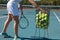 Low section of young female caucasian player practicing tennis at court on sunny day