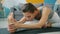 Low shot of flexible young woman doing yoga at home bending to foot on mat