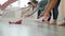 Low shot of yoga class students unrolling mats on laminate floor in light studio