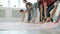 Low shot of yoga students unrolling mats in studio then walking barefoot