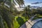 The low sun shining through palm trees of Jardin del Turia alongside Pont de les Glories Valencianes in Valencia, Spain