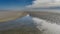 Low tide on the ocean. The seabed with undulating sandy ridges is exposed.