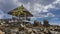 Low tide on a tropical beach. The gazebo stands on a pile of exposed granite boulders.
