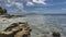 Low tide on a tropical beach. Granite boulders protrude above the clear water.