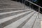 Low view across formed concrete stairs, wide outdoor city ascending staircase with stainless steel railings