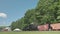 Low View of a Climax Steam Engine, Backing Up, Blowing Smoke and Steam, Passing Freight Cars