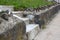 Low view of concrete steps through a stone retaining wall, green grass and sidewalk