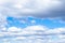 Low white and gray cumulus clouds in blue sky