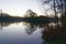 Low winter sun begins to rise over a misty lake