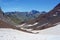 The lower Blue Lake Ibon Azul, among barren rocky mountains with snow and a blue sky in a sunny autumn, in Panticosa, Aragon