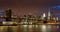 Lower Manhattan Financial District skyscrapers, Brooklyn Bridge, and East River with passing clouds at twilight. Manhattan, New Yo