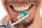 Lower part of face of man and toothbrush