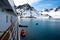 Lowering orange lifeboat to water in Arctic waters, Svalbard. Abandon ship drill. Lifeboat training. Man over board drill