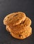 Lowkey picture of stack of chocolate chip cookies on dark stony background, close-up, shallow depth of field