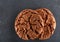 Lowkey picture of two chocolate cookies on dark background, close-up, shallow depth of field