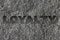 Loyalty etched in bold, dark gray text on black granite