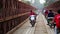 LUANG PRABANG,LAOS - APRIL 2014: motorbikes crossing historical iron bridge