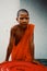 Luang Prabang / Laos - JUL 06 2011: young buddhist monk playing around inside a trash bin while jump scarring the passing by peopl