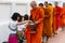 Luang Prabang, Laos - May 2019: Laotian people making offerings to Buddhist monks during alms giving ceremony