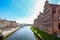 Lubeck, Germany, April 17, 2023: Historic salt store buildings and promenade with cafes on the banks of the river Trave in the old