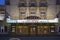 The Lucas Theatre For the Arts with a marquee in lights in a white building with green trim with blue sky at sunset in Savannah