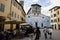 LUCCA, ITALY - OCTOBER 5, 2017: People walk in the square in front of San Frediano Basilica. Typical lifestyle scene of ancient