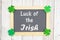 Luck of the Irish text on a chalkboard with green shamrocks