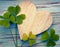 Lucky clovers with an old wooden heart on a blue vintage wood b