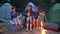 Lucky family weekend in forest, mother and two children sitting around on straw bale beside balefire, mom and kids