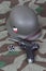 Luger P08 Parabellum handgun, helm and medal Iron Cross on camouflaged background