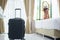 Luggage in modern hotel room with happy young adult female relaxing nearly window, asian woman tourist looking to beautiful nature