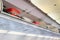 Luggage overhead compartment with hand-luggage in airplane or aircraft cabin interior