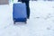 Luggage Suitcase with Snow, Tourist dragging Baggage during walking on snowy walkway. Winter travel, Journey and Vacation concept