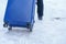 Luggage Suitcase with Snow, Tourist dragging Baggage during walking on snowy walkway. Winter travel, Journey and Vacation concept