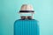 Luggage with woven beach hat and sunglasses on green background minimalistic vacation concept