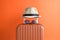 Luggage with woven beach hat and sunglasses on orange background minimalistic vacation concept