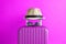 Luggage with woven beach hat and sunglasses on pink background minimalistic vacation concept