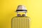 Luggage with woven beach hat and sunglasses on yellow background minimalistic vacation concept