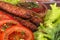 Lulia kebab on a salad with tomatoes and dill