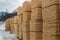 Lumber warehouse in the open air. Wooden beam, planks of wood, stacked in stacks. Construction material