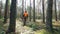 A lumberer in uniform walks in woods.