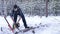 Lumberjack chainsaw manual sawing wood in the winter snowy forest